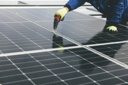 a-person-working-on-a-solar-panel.jpg a person working on a solar panel